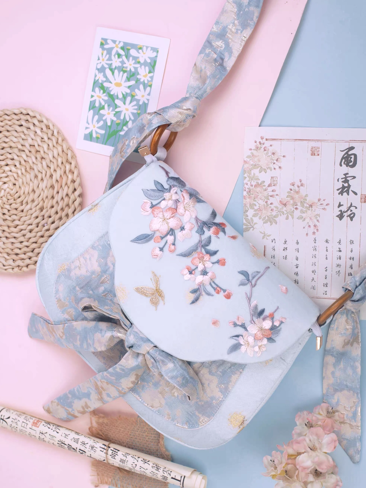 Sky blue cherry blossom embroidered Chinese crossbody bag with wooden ring hardware gold floral jacquard bow strap and Tang style butterfly design