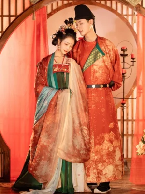 Couple wearing coordinated Tang Dynasty Chinese wedding hanfu with groom in red round-collar robe and bride in green and red traditional dress