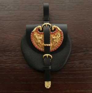 Tang Dynasty style Diexie Hanfu waist pouch with textured black curved body, paired gold-tone horse plaques, red jewel-like accents, black straps, and gold hardware photographed on a dark wooden surface