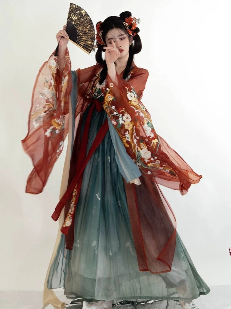 Back view of a Tang Dynasty embroidered Heziqun Hanfu dress showing flowing translucent rust red sleeves, dark teal pleated skirt, and trailing red waist sash