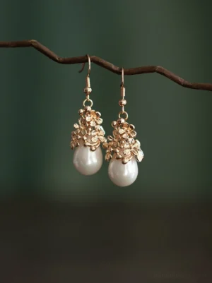 Tang Dynasty inspired floral pearl drop Chinese hook earrings displayed on a twisted branch