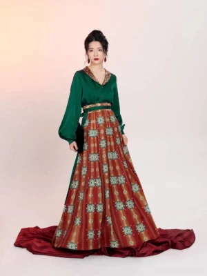 Full front view of a modern Tang Dynasty Hanfu two-piece set with emerald green satin long sleeve blouse, embroidered lapel, lantern sleeves, high-waisted red printed wrap skirt, and flowing traditional Chinese silhouette