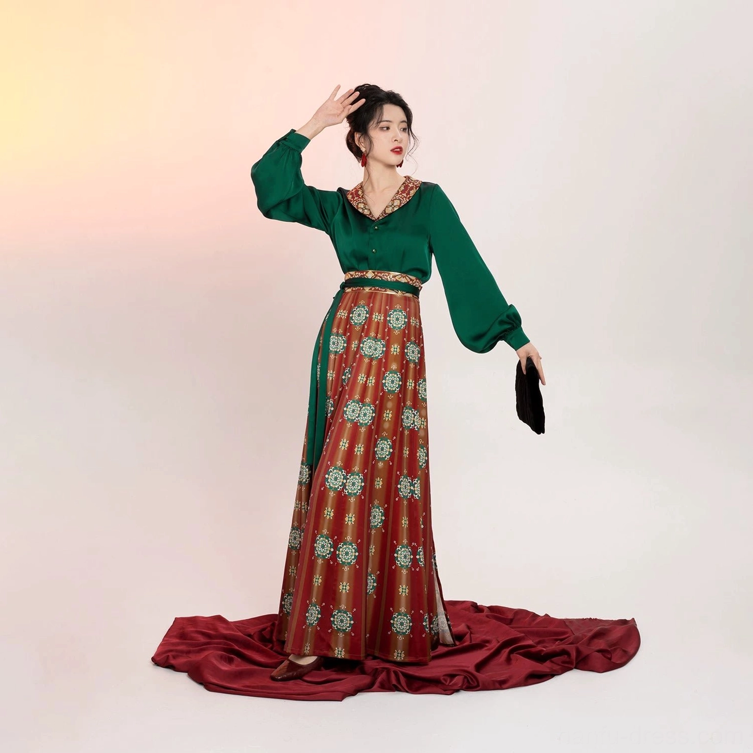 Three-quarter view of a modern Tang Dynasty Hanfu set highlighting the emerald satin blouse, flowing lantern sleeves, red printed wrap skirt, and high-waisted traditional Chinese styling