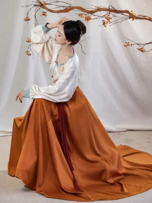 Side profile of a woman wearing a flowing Tang Dynasty Hanfu outfit with ivory round collar top, blue sleeve trim, and long trailing pleated wrap skirt