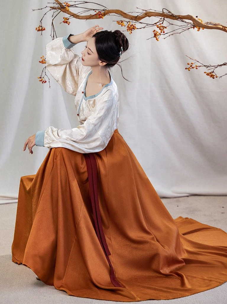 Side profile of a woman wearing a flowing Tang Dynasty Hanfu outfit with ivory round collar top, blue sleeve trim, and long trailing pleated wrap skirt