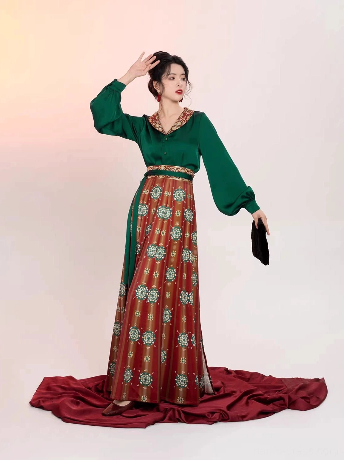 Elegant Tang Dynasty Hanfu full set with raised sleeve pose, flowing red printed wrap skirt, emerald green satin top, lantern sleeves, and graceful movement for photography