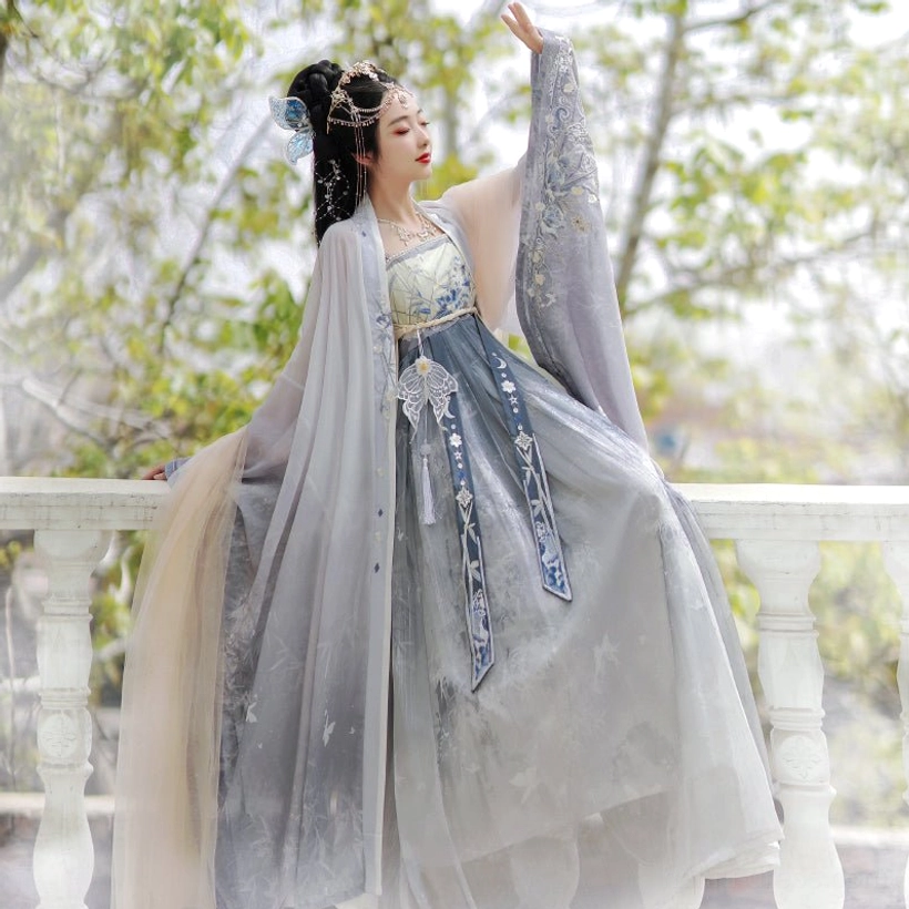 Blue Tang Dynasty Hanfu Heziqun complete set side view, showing the long flowing wide sleeve coat, beige wrap dress, delicate embroidery and layered drape