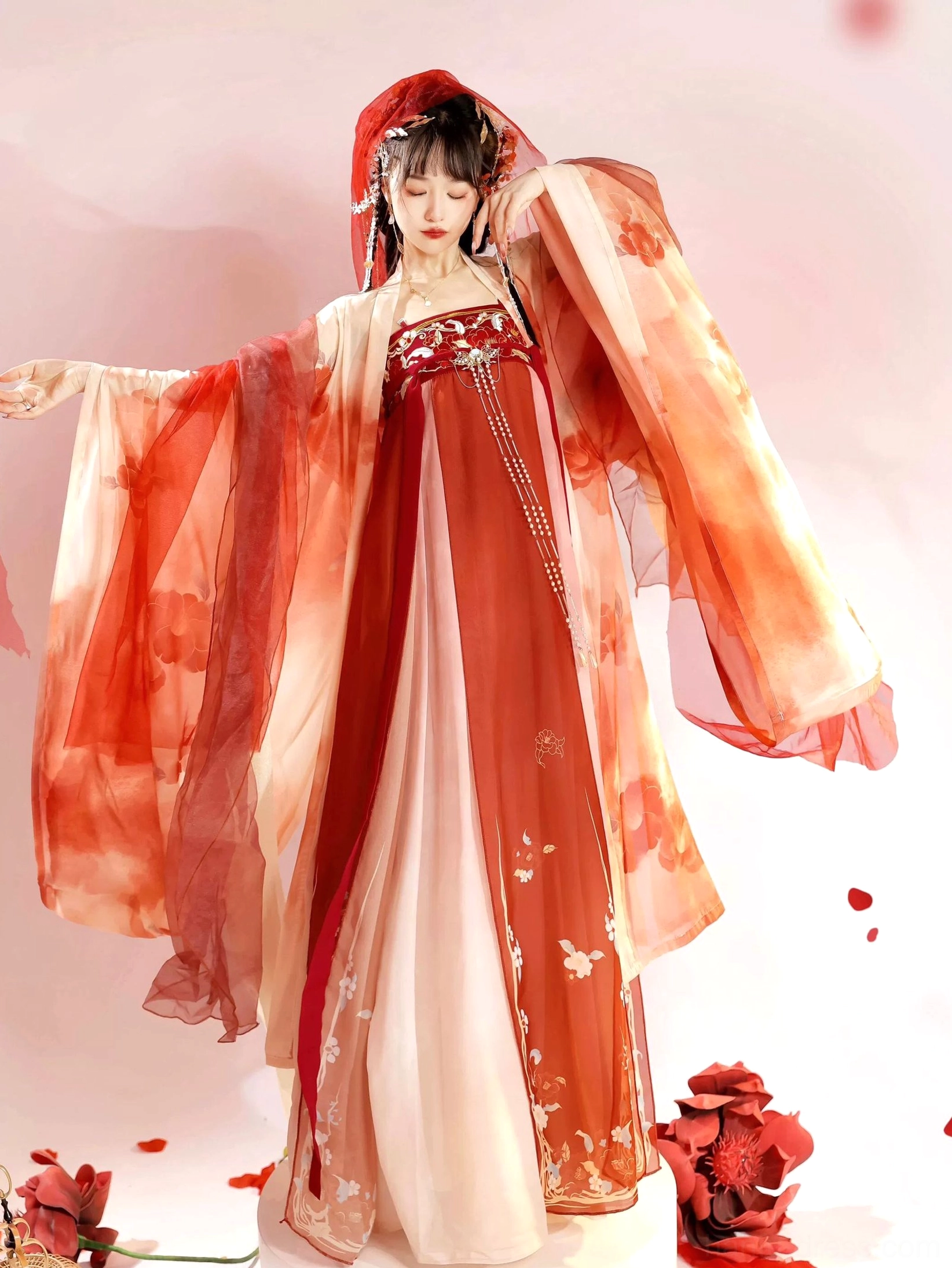 Side view of a Tang Dynasty Hanfu Heziqun ensemble showing fluttering wide sleeves, red and cream gradient fabric, and embroidered front skirt panels