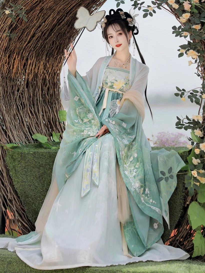 Green Tang Dynasty Hanfu Heziqun dress set featuring floral embroidered wide sleeve robe and layered skirt, modeled in a wicker flower arch setting
