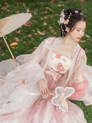 Side view of a Tang Dynasty style Hanfu Heziqun outfit with translucent wide-sleeve outer robe, scattered floral embroidery, flowing pink gradient skirt, and elegant Chinese historical fashion styling
