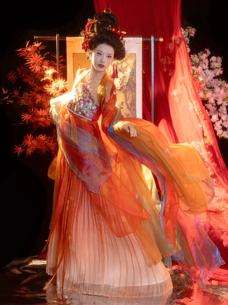 Tang Dynasty Hanfu Heziqun side view with fitted floral embroidered bust top, layered sheer skirt, and warm orange to pink gradient fabric
