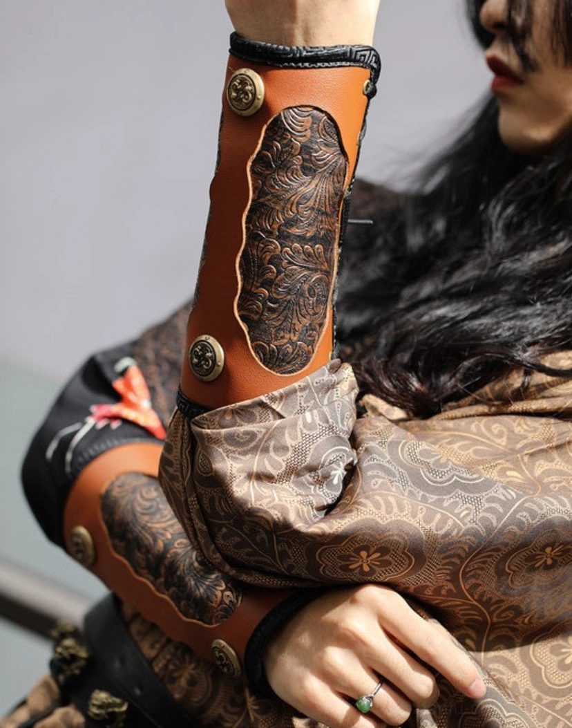 Close up detail of embossed leather Hanfu bracers with floral carving metal buckles and patterned wide sleeves from the River Essence Tang Dynasty outfit