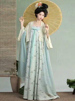 Front full-body view of a blue Tang Dynasty Hanfu Qixiong Ruqun dress set with cream cardigan, floral styling, traditional hair accessories, and yellow oil-paper umbrella