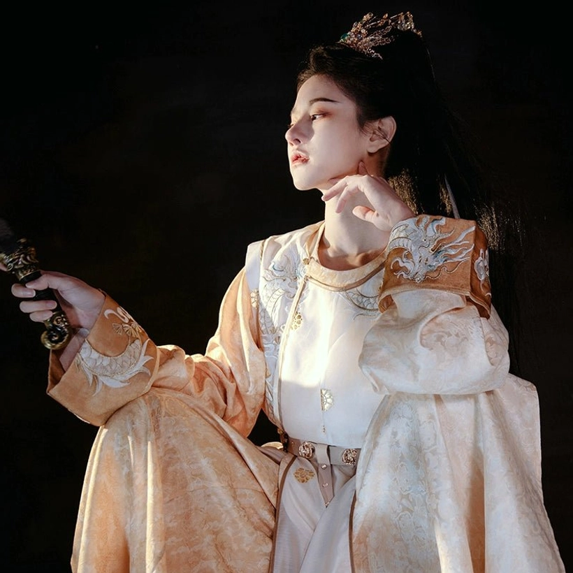 Side profile of Tang dynasty hanfu robe with large embroidered shoulder and cuff motifs, round neckline, adjustable waist belt, and traditional sword styling