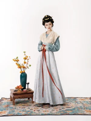 Three-quarter front view of Tang Dynasty style Hanfu with dusty blue round-collar top, beige patterned Beizi vest, and red waist sash