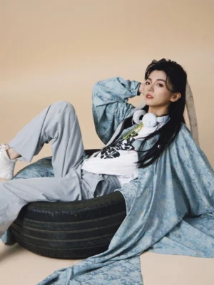 Tang Dynasty Hanfu robe in dusty blue satin with flowing long sleeves styled as a modern gender-neutral Chinese round-neck robe outfit in a studio