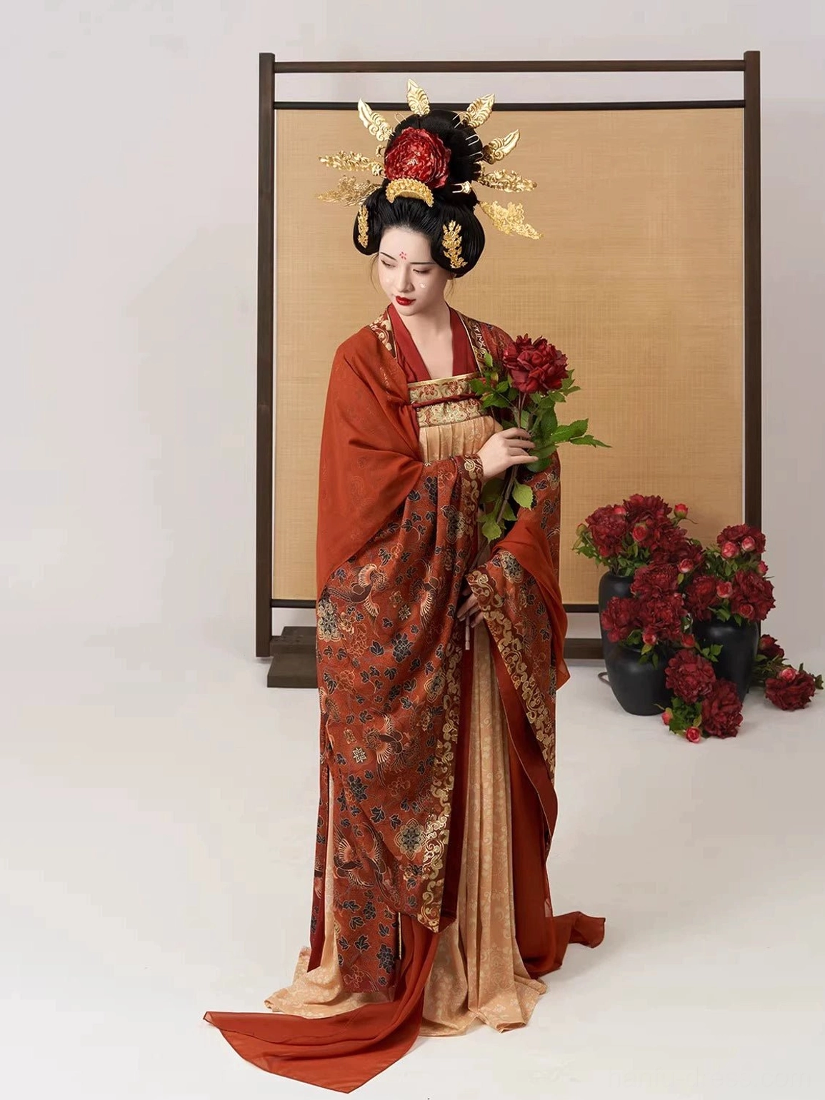 Three-quarter side view of a woman in a Tang Dynasty Hanfu set with intricate floral outer robe patterns, matching floor-length skirt train, wide sleeves, and red peony bouquet