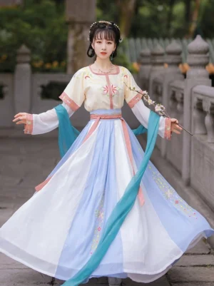 Front full-body view of a Tang Dynasty style U-collar Qiyao Ruqun Hanfu set in cream yellow, pink, white, light blue, and cyan with floral embroidery in a traditional Chinese courtyard