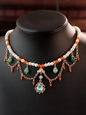 Tang Dynasty inspired Hanfu Yingluo Chinese necklace displayed on a black jewelry mannequin with pearl-like beads, orange and green accents, dangling red bead chains, and an ornate sky-blue gemstone pendant