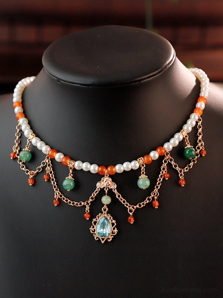 Tang Dynasty inspired Hanfu Yingluo Chinese necklace displayed on a black jewelry mannequin with pearl-like beads, orange and green accents, dangling red bead chains, and an ornate sky-blue gemstone pendant