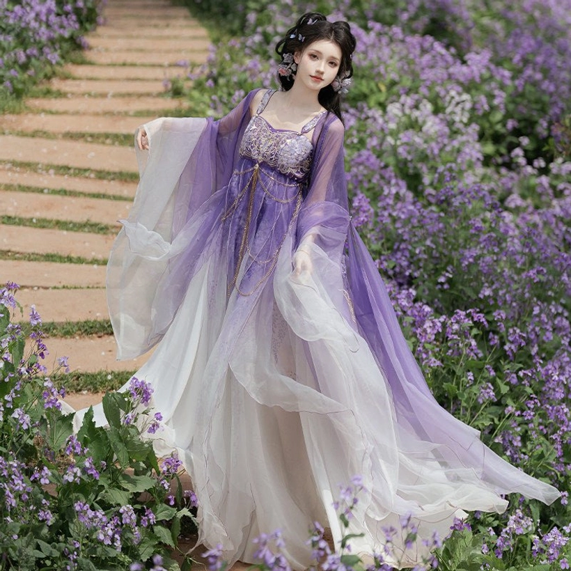 Side three-quarter view of a complete Tang Dynasty Hezi Hanfu set with flared wide sleeves, long trailing gradient skirt, and matching purple ivory styling