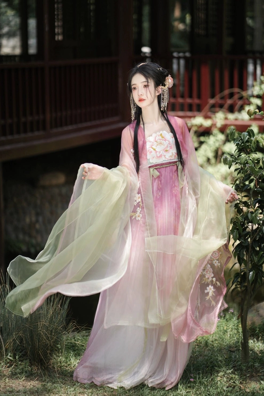Side view of Tang Dynasty Heziqun Hanfu showing the flowing pink and light green sheer shawl, long embroidered skirt, and graceful layered silhouette