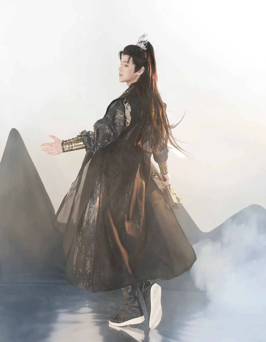 Back three-quarter view of a complete Tang Dynasty inspired male hanfu outfit showing the long sheer black outer robe, layered navy clothing, traditional styling, and dark boots