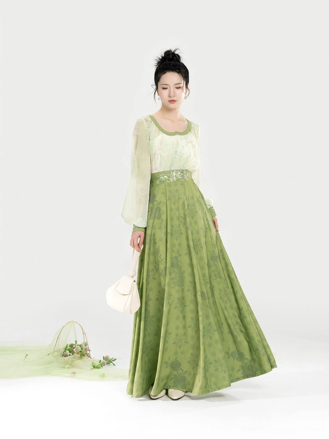 Tang Dynasty modern Hanfu two-piece set shown from a three-quarter front view with sheer off-white lantern sleeves, embroidered waist trim, and a flowing sage green eight-panel skirt