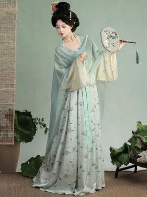 Left-side full-body view of a Tang Dynasty Qixiong Hanfu Ruqun in a light blue floral wrap dress with cream cardigan, styled with traditional Chinese hair ornaments and a tasseled silk fan
