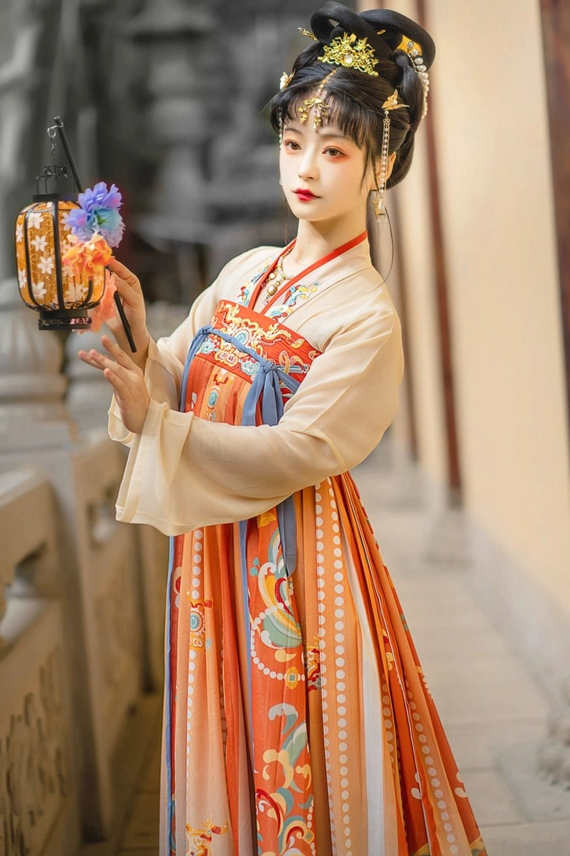 Front close-up of Tang Dynasty Qixiong Ruqun Hanfu inner top and skirt featuring an apricot cross-collar top, embroidered chest decoration, blue sash, and traditional lantern