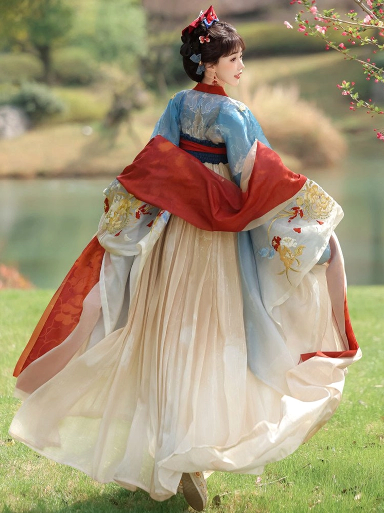 Back full-body view of Tang Dynasty Qixiong Ruqun Hanfu showing embroidered sleeves, flowing red shoulder scarves, gradient blue and cream fabric, and wide pleated skirt