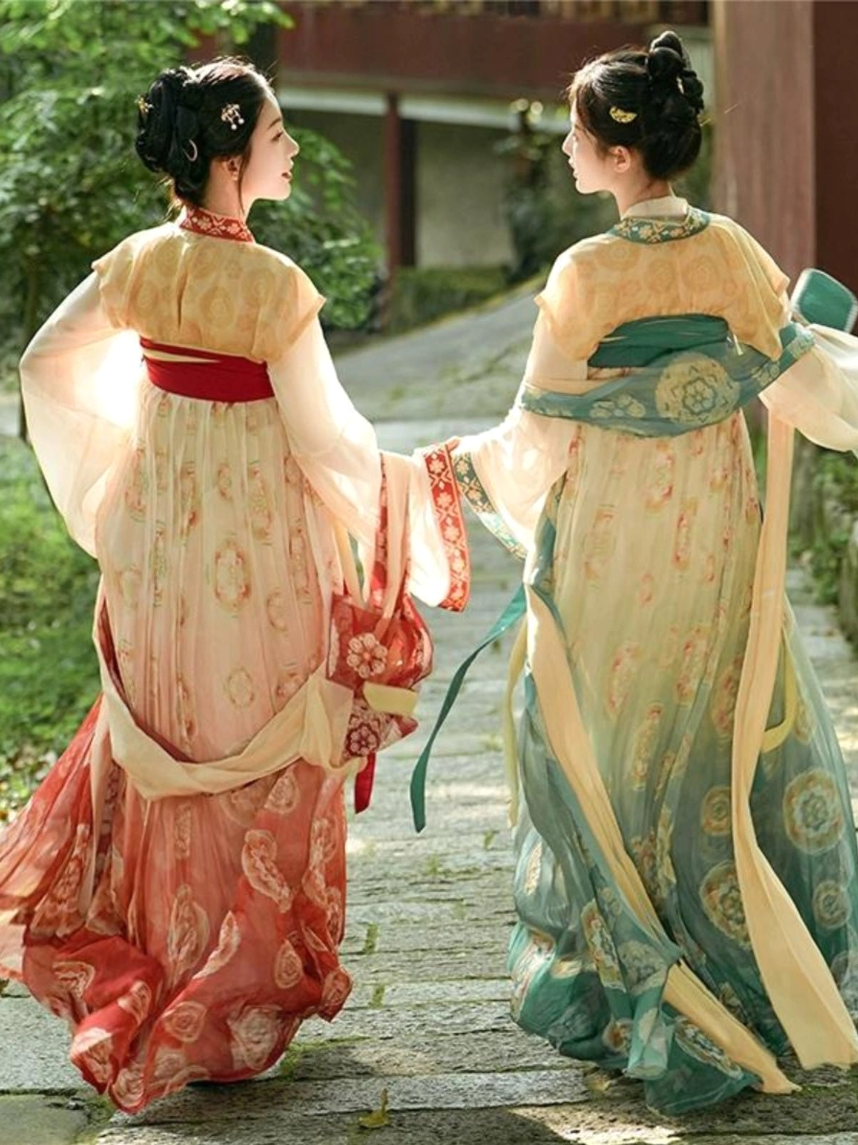 Back-side view of red and green Tang Dynasty Qixiong Ruqun Hanfu dresses showing matching waist sashes and elegant flowing silhouettes