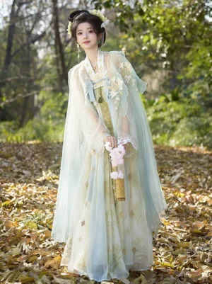 Full front view of Tang Dynasty Qixiong Ruqun Hanfu set with light cyan sheer embroidered cloak and cream yellow high waisted skirt in an autumn forest