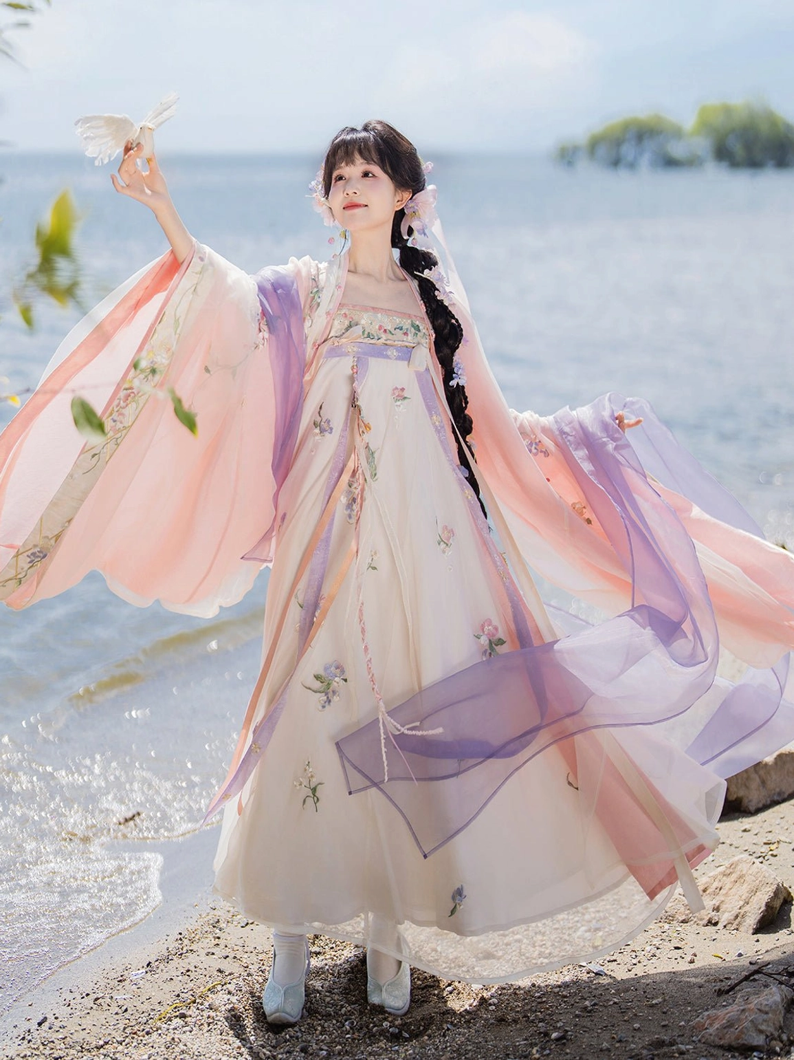 Tang Dynasty style Qixiong Ruqun hanfu with flowing sheer pink and purple sleeves and floral embroidered skirt by the seaside
