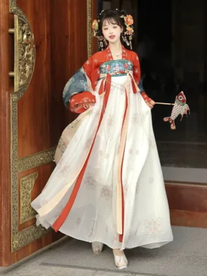 Front view of red and beige Tang Dynasty Qixiong Ruqun Hanfu dress with embroidered chest panel, patterned skirt, blue outer shawl, waist ribbons, and floral hair ornaments