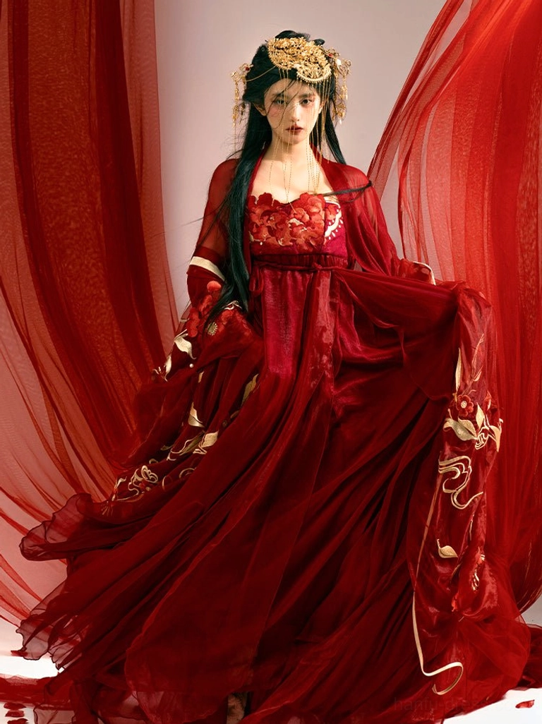 Close-up front view of a Tang Dynasty inspired red Hanfu wedding dress featuring three-dimensional floral appliqué on the bodice, gold skirt embroidery, and a sheer outer layer