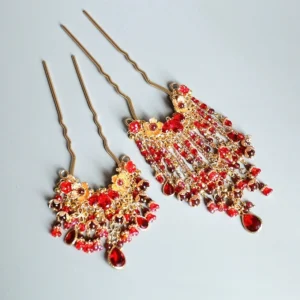 Traditional Chinese red tassel hanfu hair pin with gold floral metalwork red beads and teardrop pendant shown in a top view