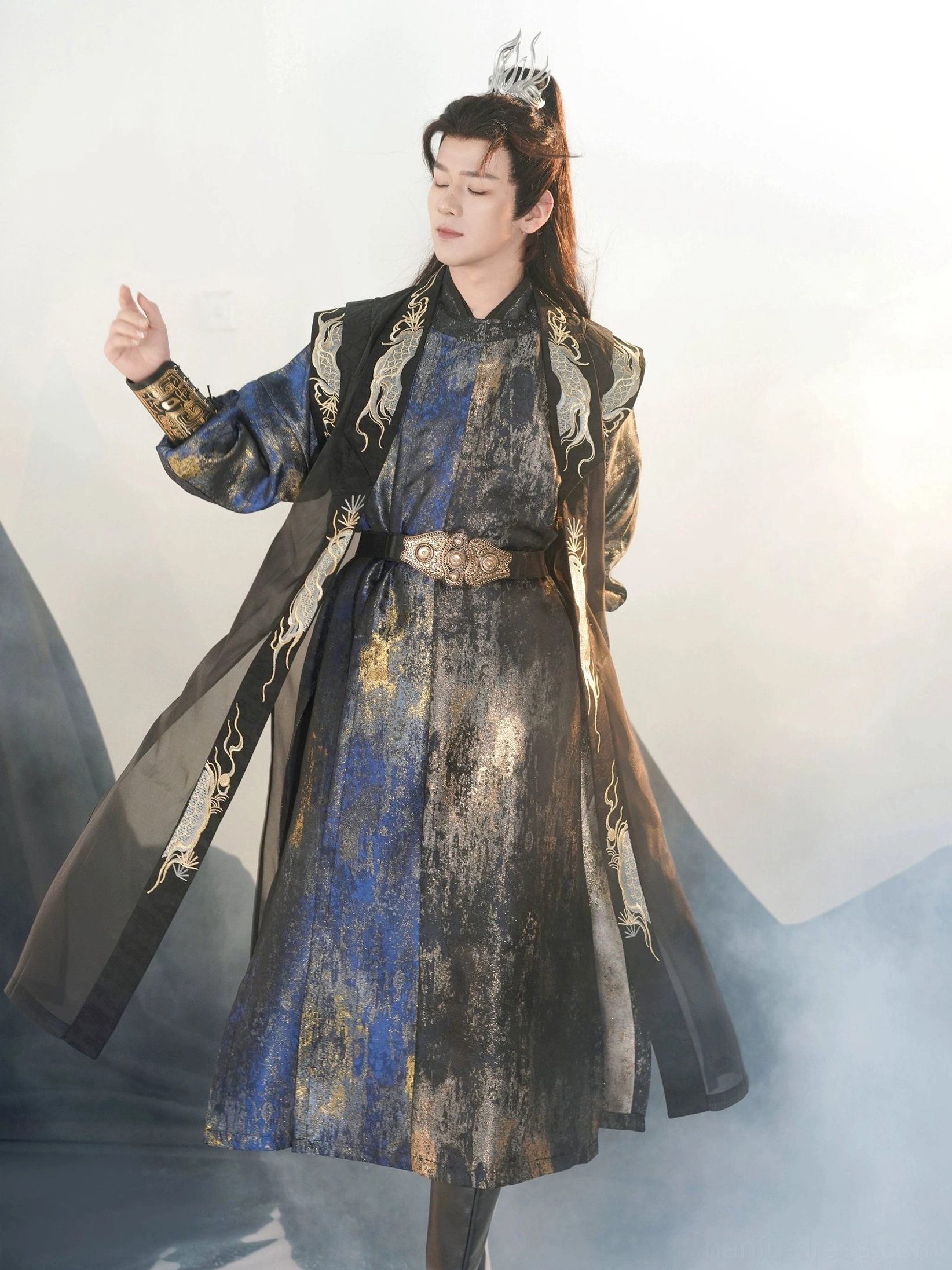 Side view of a Tang Dynasty round collar hanfu costume for men with an extra long sheer black sleeveless vest, gold dragon embroidered trim, navy robe, and dramatic flowing silhouette