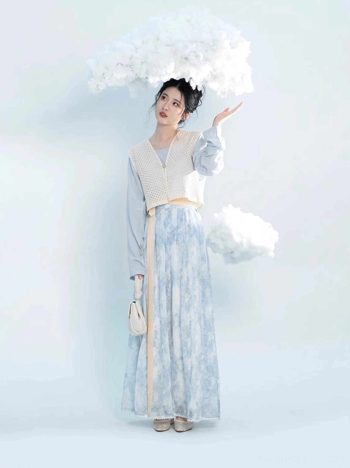 Full view of modern Tang Hanfu outfit with crocheted beige Beizi vest blue floral pleated skirt and matching white handbag