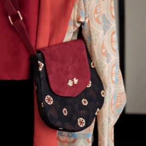 Tang-inspired crimson floral crossbody Chinese bag worn on shoulder, showing adjustable wine red strap and vintage floral saddle bag silhouette