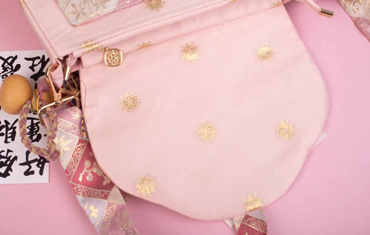Interior and shoulder strap detail of pink blossom embroidered Chinese crossbody bag with metal zipper and gold dot lining