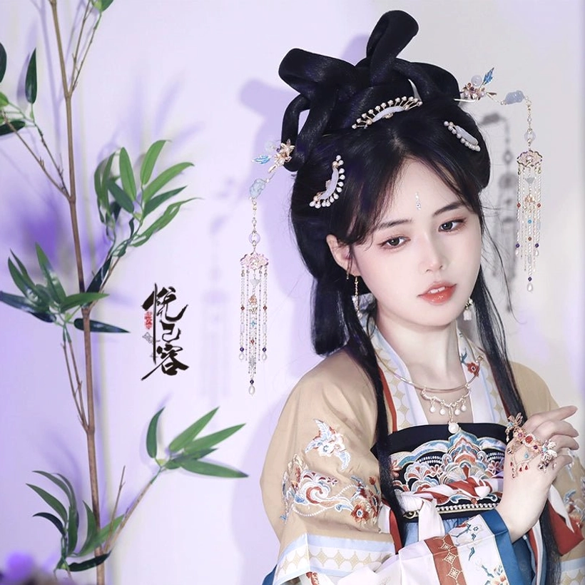 Three-quarter view of a complete Tang-style Hanfu outfit styled with layered Chinese hair jewelry, tassel hair ornaments, necklace, and hand accessories