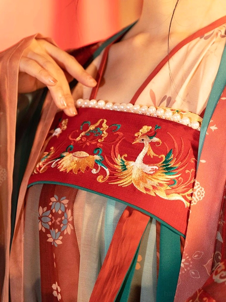 Close-up of Tang wedding hanfu bridal bodice with red double phoenix embroidery pearl neckline trim floral fabric and contrasting shoulder straps