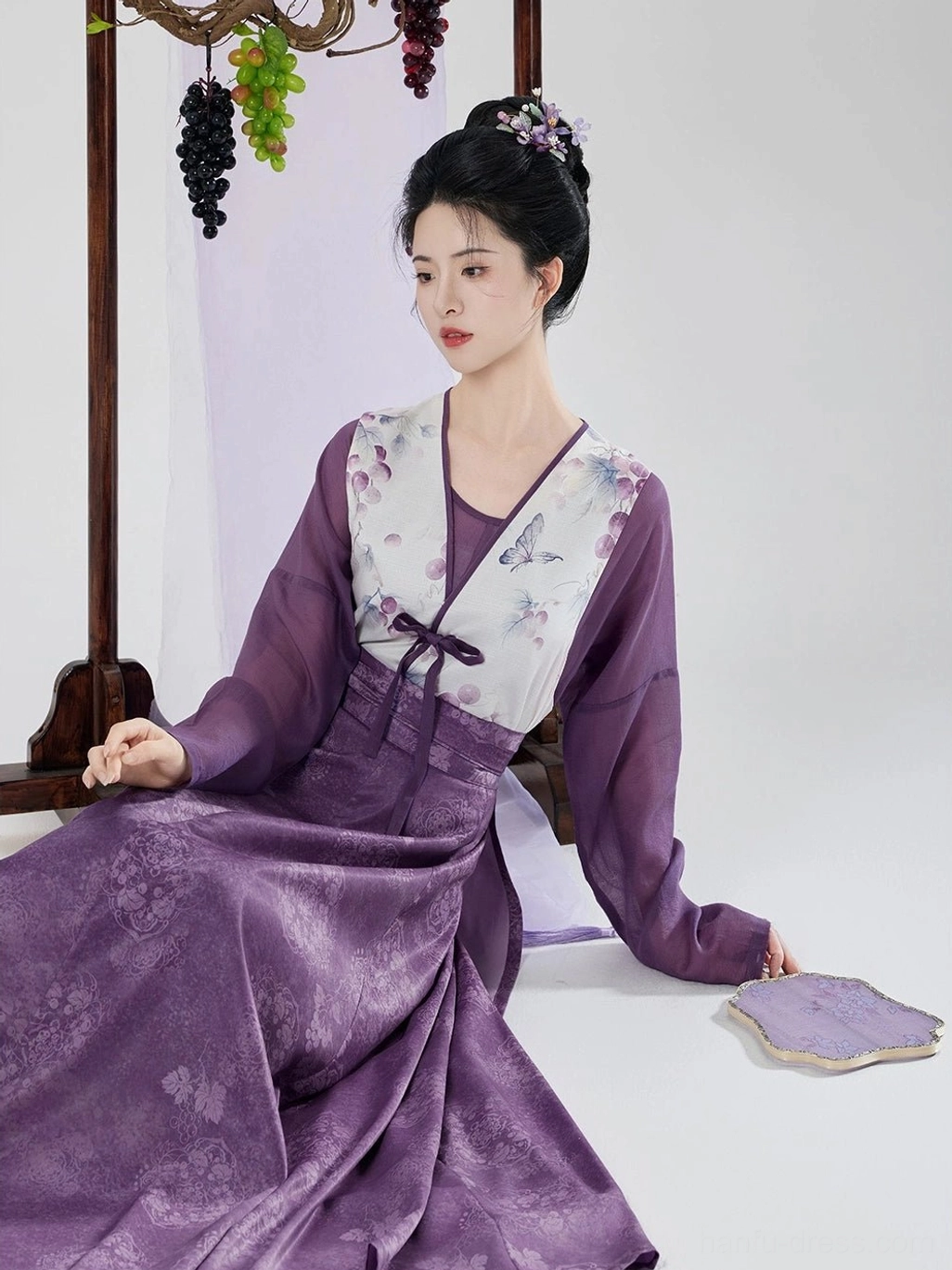 Seated side view of taro purple Tang Dynasty hanfu set showing tied waist sash printed beizi and long pleated skirt