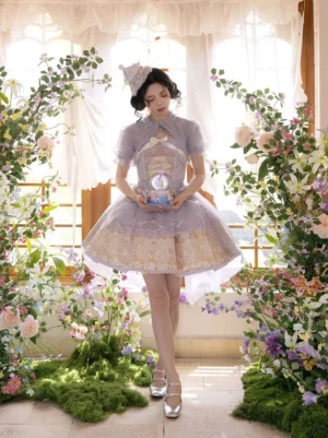 Front full-body view of a taro purple embroidered Modern Hanfu Lolita dress with champagne-gold details, flared skirt, matching mini top hat, and silver sandals in a sunlit flower conservatory