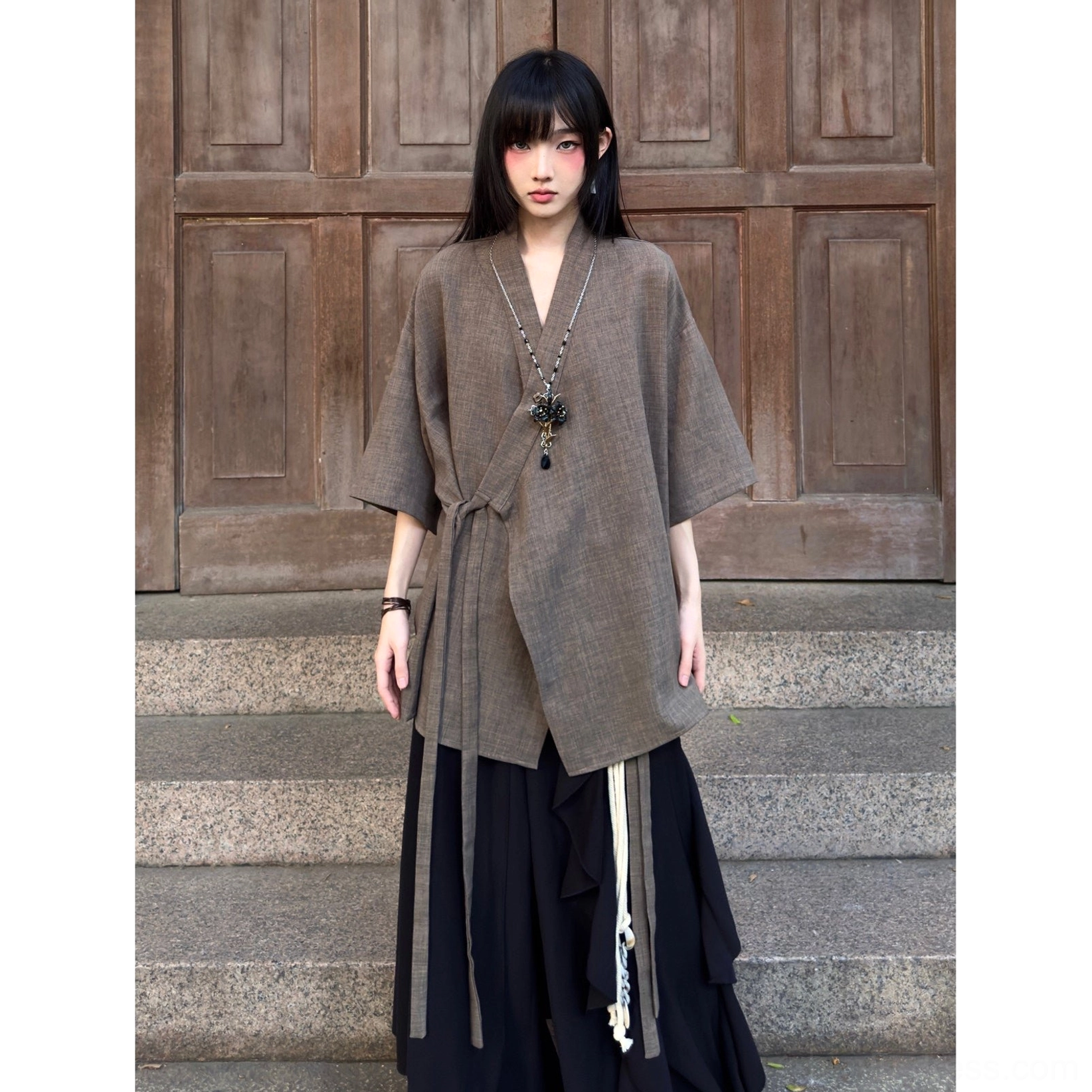 Full-body view of a taupe brown modern Hanfu cardigan with side tie closures and black layered wide-leg trousers