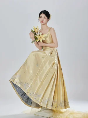 Thousand Golden Lily champagne gold Ming Dynasty Hanfu bustier and pleated mamianqun skirt set with lily embroidery, model seated with yellow lily bouquet