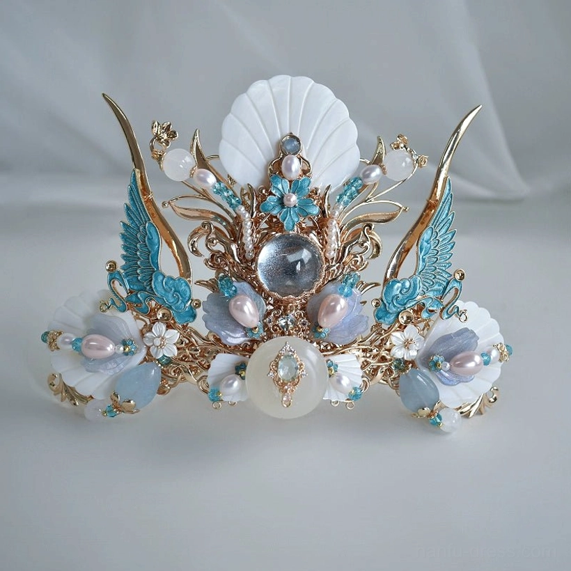Three-quarter product view of Tidal Sea Spirit Chinese style hair crown on gray fabric, displaying polished gold-tone metalwork and blue white petal-inspired decorations