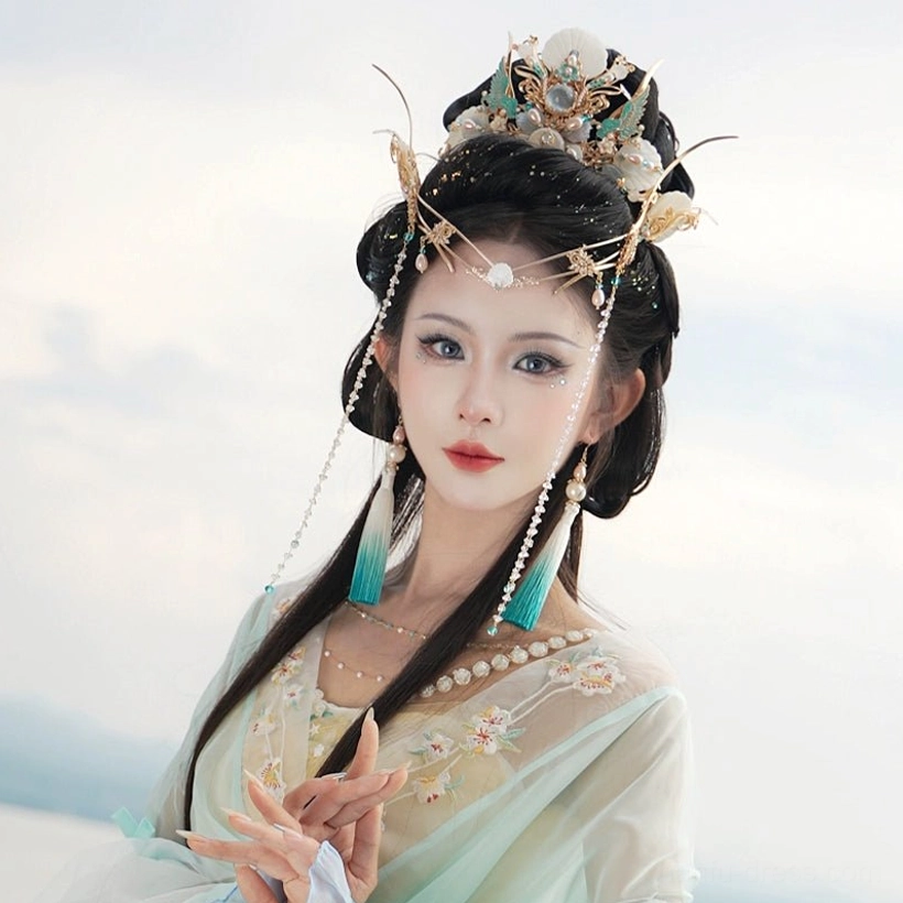 Tidal Sea Spirit full Hanfu hair ornament set styled with light yellow green Hanfu outdoors, showing elegant crown, forehead jewelry and blue tassel accents