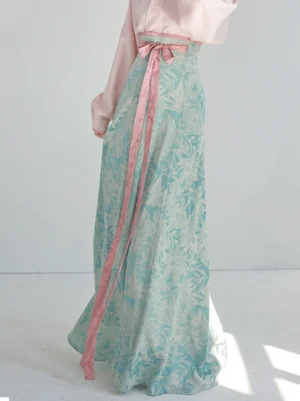 Back three-quarter view of Tiffany Glaze modern Tang Dynasty Hanfu with pink waist sash and flowing cyan printed wrap skirt